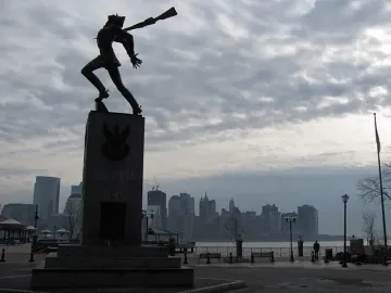 Katyń Memorial with a dark soldier-like figure on a tall stone pedestal marked KATYN 1940.