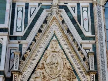 Porta della Mandorla tympanum with carved figures, mosaic detail, and patterned stone facade on Florence Cathedral