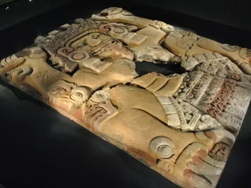 Tlaltecuhtli monolith with an elaborate splayed stone figure and a visible break across the middle