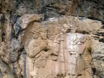 Ivriz relief showing two carved figures, one holding a staff and grapes.