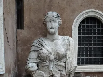 Madama Lucrezia, a weathered stone statue of a draped woman with an eroded face on a pedestal.