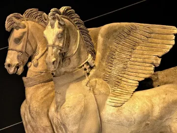 Detail of the Winged Horses of Tarquinia showing two winged horse heads and upper bodies in relief.