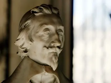 White marble bust of Cardinal Richelieu with a mustache, pointed goatee, and wavy shoulder-length hair.