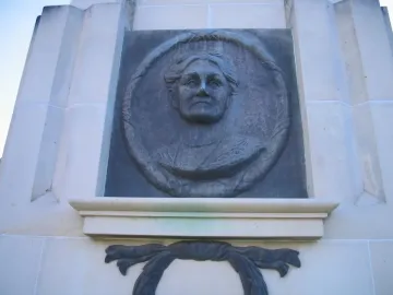 Edith Cowan Memorial relief bust set in a light stone structure with a circular frame and decorative draped element below.