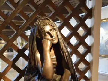 La Douleur bronze sculpture of a seated figure resting its chin on one hand