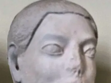 Sabouroff Head, a light-colored sculptural male head with stylized eyes, a damaged nose and mouth, and short sculpted hair and beard.