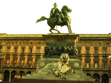 Victor Emmanuel II Monument with a bronze equestrian statue atop a marble pedestal, featuring a reclining lion sculpture and relief figures.