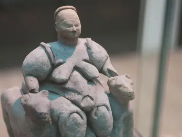 Seated Woman of Çatalhöyük earthenware sculpture showing a seated obese woman between two animal heads.