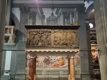The Passion Pulpit bronze relief filled with figures inside a basilica interior.