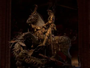 Saint George and the Dragon sculpture showing a knight in gilded armor on a rearing horse over a defeated dragon.