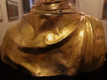 The back and shoulders of the Saint Rossore Reliquary, showing gilded folds and an ornamental band near the top.