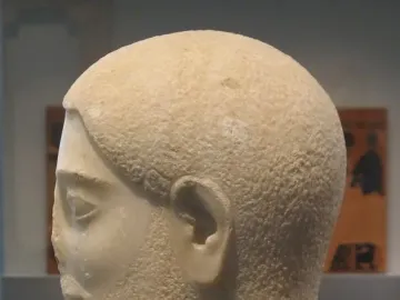 Sabouroff Head in light-colored stone, shown in profile facing left with textured hair and beard.