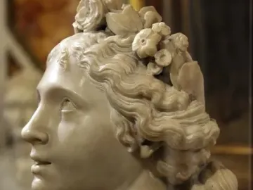Blessed Soul, a white marble bust of a young woman in profile with wavy hair and floral ornaments, gazing upward.