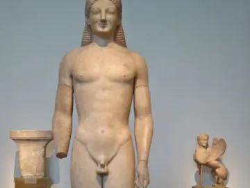 Kouros marble statue of a nude male figure with a missing left forearm and long braided hair.