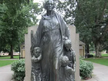 Pioneer Mother Memorial sculpture of a robed figure on a stone base with three smaller figures at her feet.