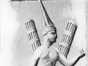 Yazılıkaya relief carving of a figure in profile wearing a tall headdress and pleated skirt, holding a staff.