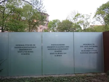 Frosted glass wall of the Memorial to the Murdered Sinti and Roma of Europe with memorial text in German, Romani, and English.
