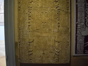 Detail of the Raimondi Stela showing a stylized anthropomorphic figure with an ornate headdress and patterned staffs.