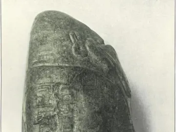 Left side of the Tuxtla Statuette showing carved glyph columns and a stylized face near the top.