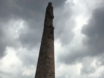 The Roundabout of the Disappeared stone monument rising above a circular base covered with banners and signs.