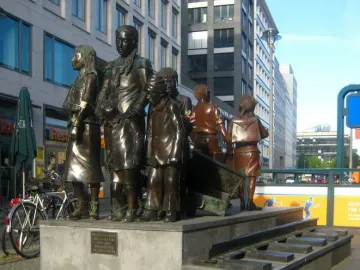The Trains to Life – Trains to Death memorial with bronze child figures on a stone platform and railway tracks leading down the steps.
