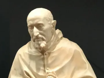 Marble bust of Cardinal Roberto Bellarmine showing a bearded man in a hooded robe with clasped hands.