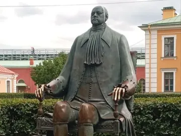 Peter I Monument showing a bronze seated figure on a throne behind a decorative fence.