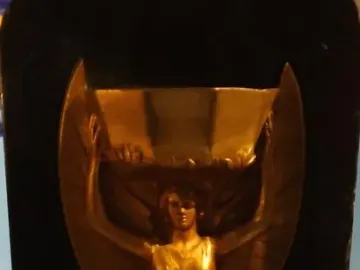 Jules Rimet Trophy replica with a winged female figure holding a cup overhead on a dark base.