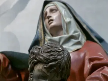 Close-up of the Pietà sculpture showing Mary supporting the lifeless body of Christ.