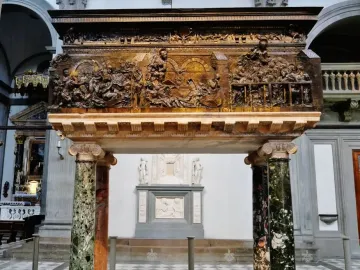 The Resurrection Pulpit with dark relief panels above two polished marble columns on a checkered floor.