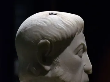 White marble bust of Eutropius in profile facing right, with short wavy hair, a beard, and a prominent nose.