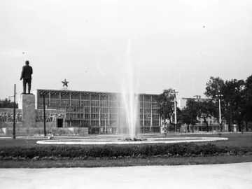 The Stalin Monument seen from behind, with a fountain and a star-topped building in the background.