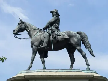 Winfield Scott equestrian statue in bronze against a blue sky with scattered clouds.
