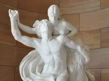Mercury and Psyche sculpture showing a man with one arm raised and a seated woman holding hands on a rocky base.