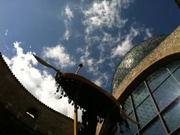 Rainy Taxi suspended between stone buildings and a glass dome under a blue sky.