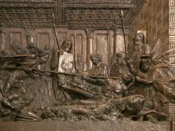 Bronze relief from The Resurrection Pulpit showing a crowded indoor scene with figures gathered around a central body.