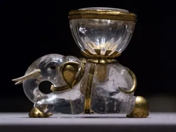 Crystal elephant with gold accents carrying a clear salt cellar on its back.