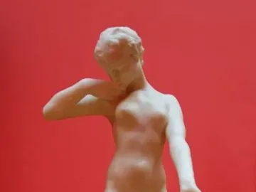 Standing Fauness, a pale nude female sculpture with her head bowed and one hand at her neck.