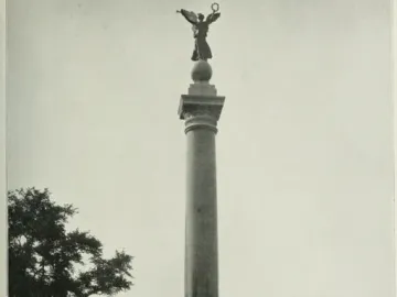 Battle Monument with a tall column topped by a winged female figure holding a wreath aloft, standing on a stepped base with smaller surrounding pedestals.