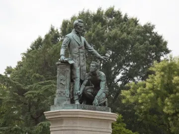 The Emancipation Memorial showing Abraham Lincoln standing over a kneeling man with broken shackles on a stone pedestal.