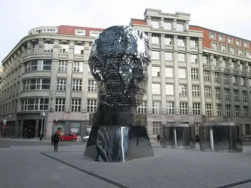The Head of Franz Kafka sculpture in Prague, a towering reflective head made of horizontal mirrored panels.