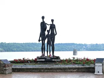 Monument to the Victims of Fascism bronze sculpture of two adults and a child beside a river