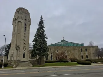 National Shrine of the Little Flower with its stone crucifixion tower beside the sanctuary and green domed roof.