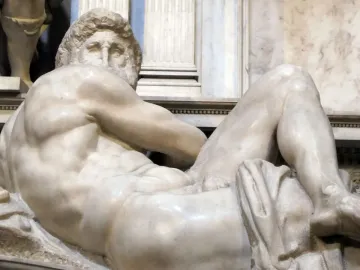 The Day from the Medici Tombs, a reclining white marble male figure with a muscular nude body and turned head.