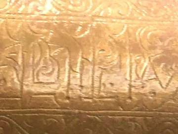 Close-up of the Lion of Monzon showing gilded calligraphic inscription and floral ornament