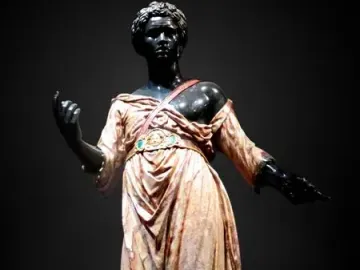 Moor of Borghese statue showing a dark-skinned figure in a patterned tunic and boots with one arm raised.