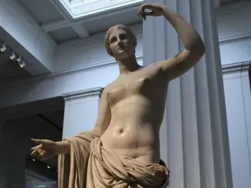 Townley Venus marble statue with one arm raised and draped fabric over the lower body.