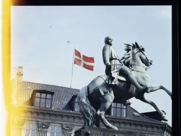 Absalon Monument, a green equestrian statue on a stone pedestal with a tall spire in the background.
