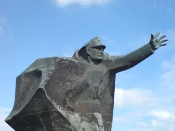 Kościuszkowców Memorial bronze statue of a uniformed figure with one arm outstretched on a stepped base