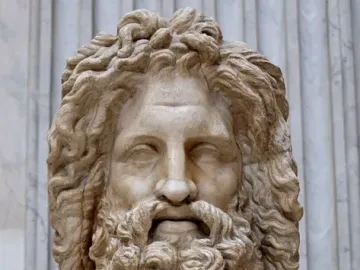 Zeus of Otricoli marble bust with curly hair and a beard on an inscribed pedestal.